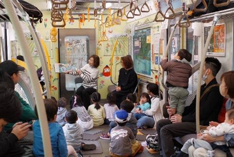 女性が子供たちに絵本を読み聞かせている様子