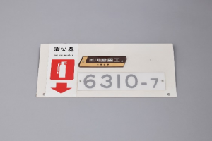 三田線（6300）の車内車号・製造銘板（中間車）化粧板付きの画像