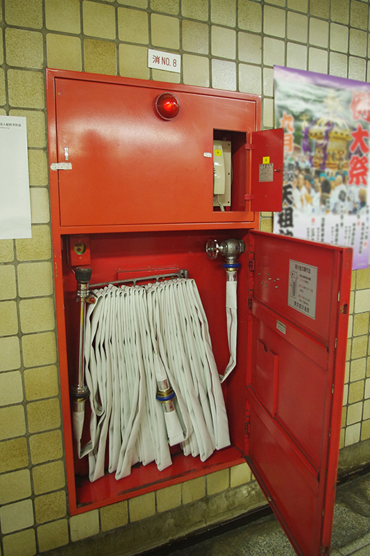 駅構内の壁に設置された消火栓と非常電話。緊急時には開けて対応する。